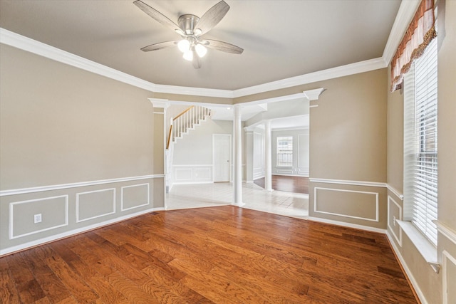 1301 Wilderness Pines Dr, Friendswood, TX 77546 - spare room with decorative columns, ceiling fan, ornamental molding, wood finished floors, and a decorative wall