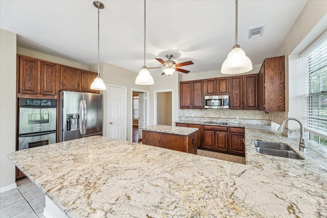 1301 Wilderness Pines Dr, Friendswood, TX 77546 - kitchen featuring stainless steel appliances, a sink, backsplash, light stone countertops, and light tile patterned floors