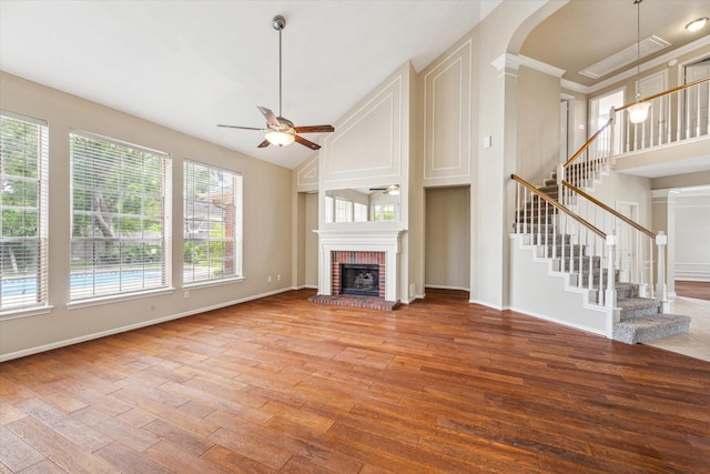 1301 Wilderness Pines Dr, Friendswood, TX 77546 - unfurnished living room featuring a ceiling fan, light wood-style flooring, a fireplace, stairway, and high vaulted ceiling