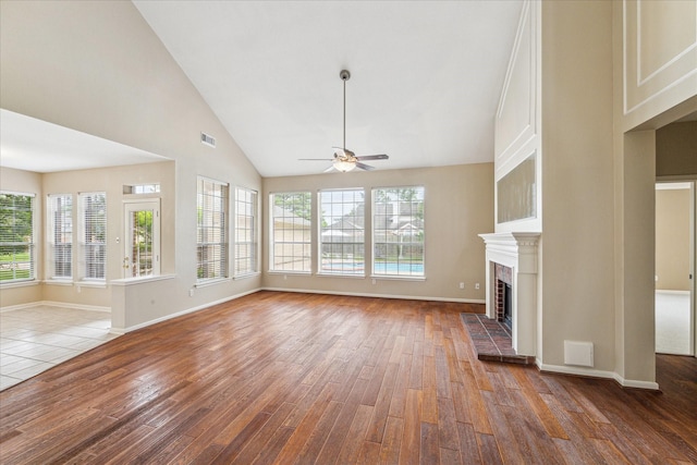 1301 Wilderness Pines Dr, Friendswood, TX 77546 - unfurnished living room featuring ceiling fan, wood finished floors, a brick fireplace, baseboards, and high vaulted ceiling