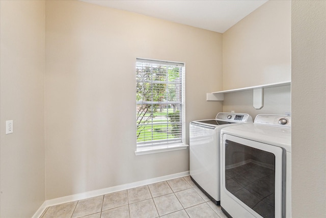 1301 Wilderness Pines Dr, Friendswood, TX 77546 - laundry room with washer and clothes dryer, plenty of natural light, light tile patterned floors, and baseboards