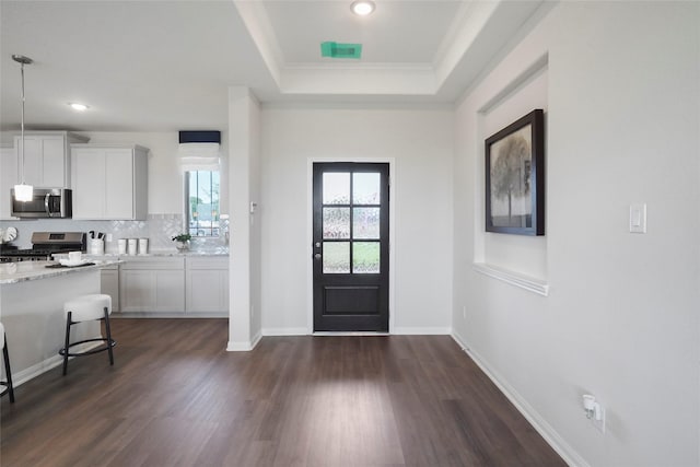 11034 Moon Light Dr, Needville, TX 77461 - foyer featuring a raised ceiling, ornamental molding, dark wood-style floors, recessed lighting, and baseboards