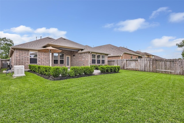 23435 Banks Mill Dr, New Caney, TX 77357 - back of property featuring brick siding, a shingled roof, and central AC unit