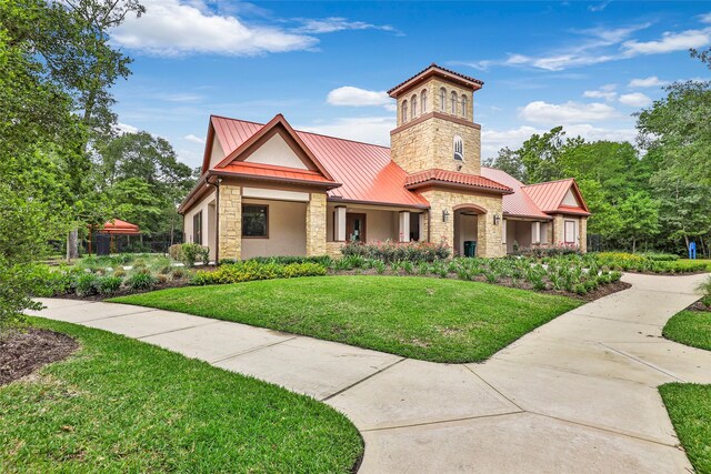 23435 Banks Mill Dr, New Caney, TX 77357 - view of front of property with stone siding, stucco siding, metal roof, a front lawn, and a standing seam roof
