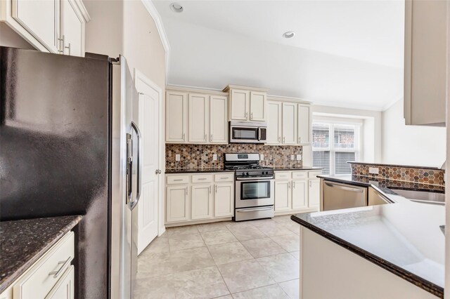 23435 Banks Mill Dr, New Caney, TX 77357 - kitchen with stainless steel appliances, backsplash, dark countertops, light tile patterned floors, and lofted ceiling