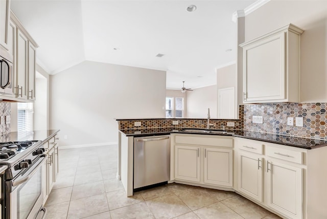 23435 Banks Mill Dr, New Caney, TX 77357 - kitchen featuring appliances with stainless steel finishes, a sink, tasteful backsplash, dark stone countertops, and a peninsula