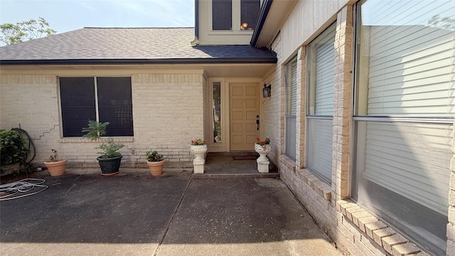 2707 Williams Grant St, Sugar Land, TX 77479 - view of exterior entry with a shingled roof and brick siding
