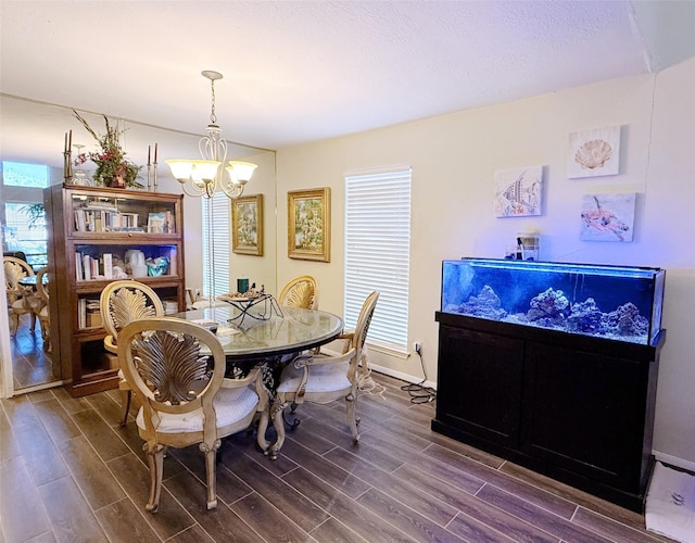 dining area with a chandelier, dark wood-style flooring, and baseboards