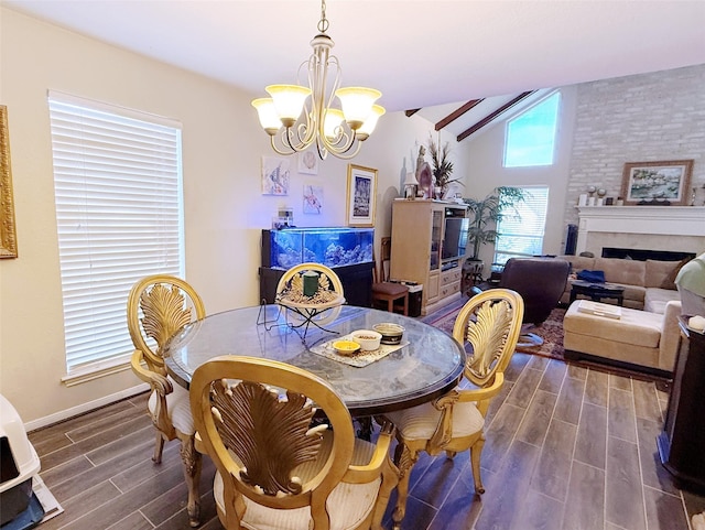 dining space with dark wood-style floors, a chandelier, a fireplace, and baseboards