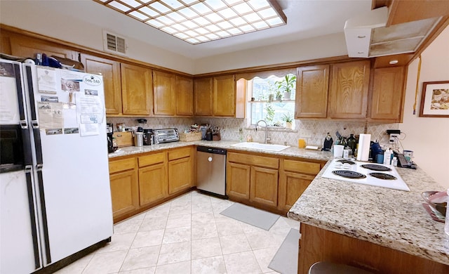 kitchen featuring white appliances, a sink, light countertops, backsplash, and light tile patterned flooring