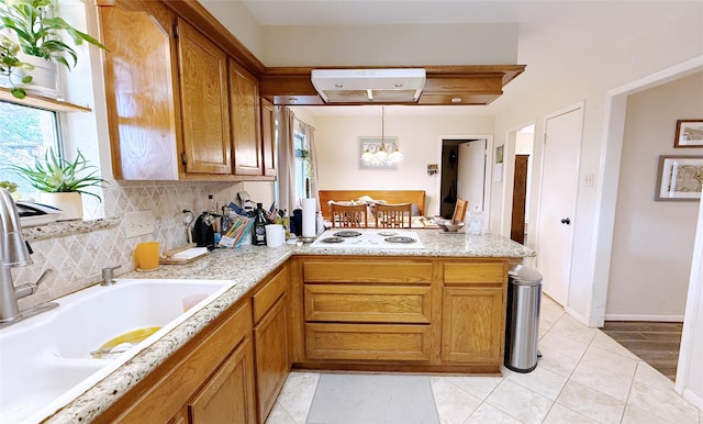 kitchen featuring a sink, a peninsula, plenty of natural light, and light countertops