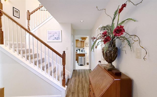 foyer featuring stairs, wood finished floors, baseboards, and recessed lighting