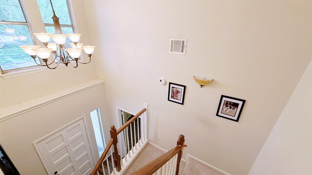 stairs featuring a chandelier and baseboards