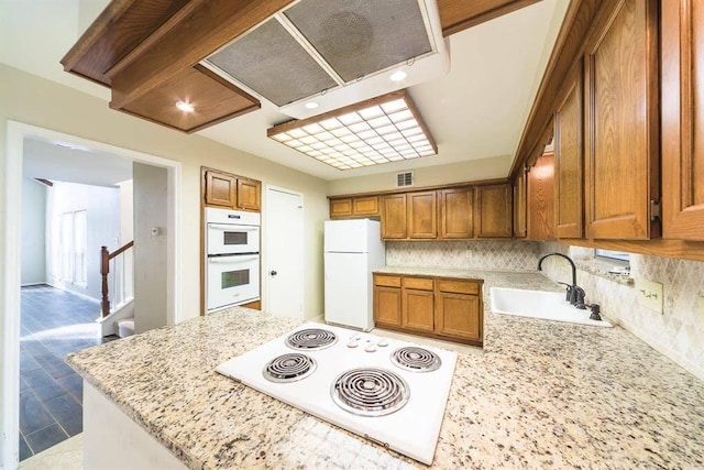 2707 Williams Grant St, Sugar Land, TX 77479 - kitchen with a sink, white appliances, brown cabinetry, and tasteful backsplash