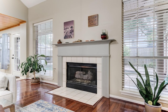 12911 Peach Meadow Dr, Cypress, TX 77429 - living room with healthy amount of natural light, a tile fireplace, wood finished floors, and baseboards