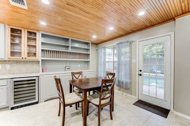 12911 Peach Meadow Dr, Cypress, TX 77429 - dining area featuring beverage cooler, wooden ceiling, baseboards, recessed lighting, and crown molding