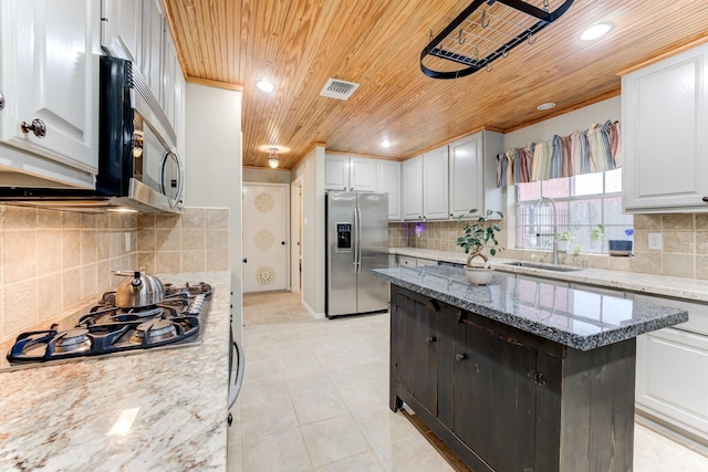 12911 Peach Meadow Dr, Cypress, TX 77429 - kitchen featuring appliances with stainless steel finishes, a sink, wood ceiling, backsplash, and white cabinets