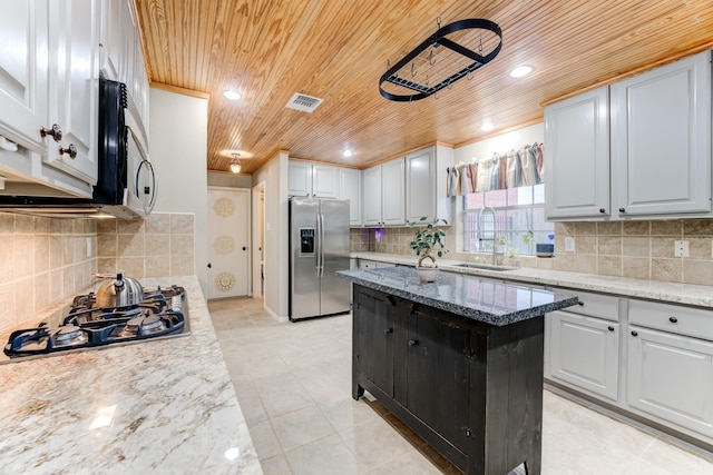 12911 Peach Meadow Dr, Cypress, TX 77429 - kitchen with stainless steel appliances, wood ceiling, a sink, decorative backsplash, and a kitchen island