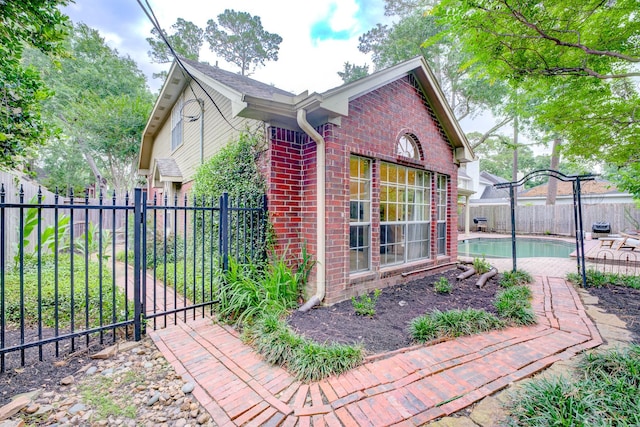 12911 Peach Meadow Dr, Cypress, TX 77429 - view of side of home featuring brick siding, a fenced backyard, and a gate