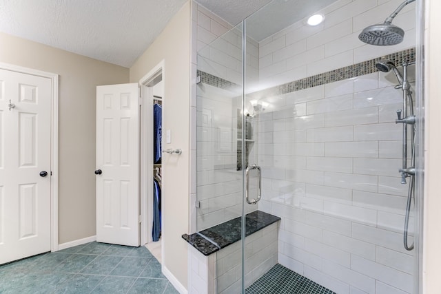 12911 Peach Meadow Dr, Cypress, TX 77429 - full bath featuring a shower stall, a textured ceiling, tile patterned flooring, baseboards, and a spacious closet