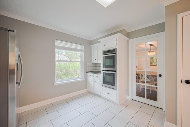 715 Cheltenham Dr, Katy, TX 77450 - kitchen with stainless steel appliances, white cabinetry, ornamental molding, backsplash, and baseboards