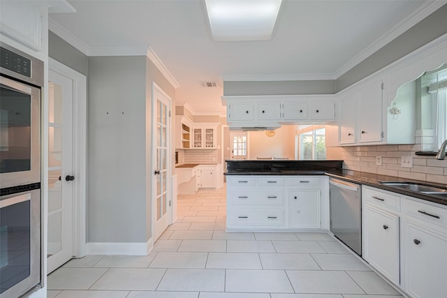 715 Cheltenham Dr, Katy, TX 77450 - kitchen featuring appliances with stainless steel finishes, a sink, backsplash, white cabinetry, and ornamental molding