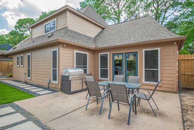 715 Cheltenham Dr, Katy, TX 77450 - rear view of house featuring a patio area, roof with shingles, fence, and outdoor dining area