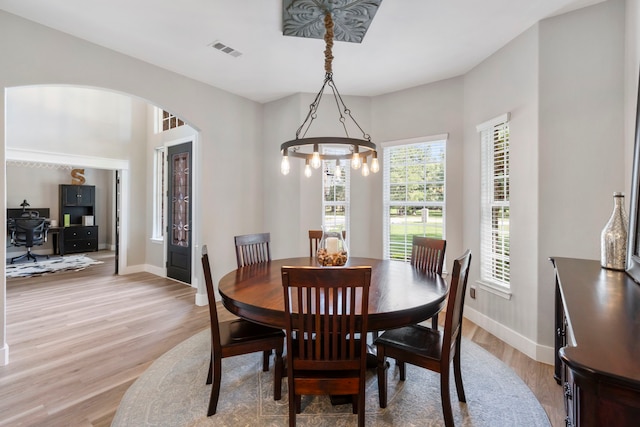 4810 Pine Wood Meadows Ln, Spring, TX 77386 - dining room featuring light wood-type flooring, baseboards, and arched walkways
