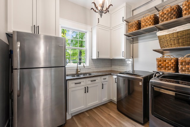 4810 Pine Wood Meadows Ln, Spring, TX 77386 - kitchen featuring freestanding refrigerator, a sink, white cabinets, and light wood-style floors