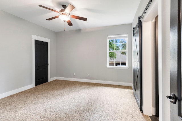 4810 Pine Wood Meadows Ln, Spring, TX 77386 - unfurnished room featuring a barn door, carpet, a ceiling fan, and baseboards