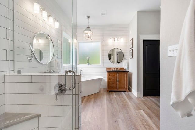 4810 Pine Wood Meadows Ln, Spring, TX 77386 - full bath with a freestanding tub, wood finished floors, vanity, and a shower with shower door