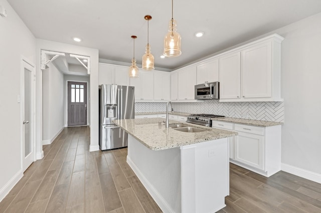 11826 Tranquility Summit Dr, Cypress, TX 77433 - kitchen featuring appliances with stainless steel finishes, a sink, wood finished floors, a kitchen island with sink, and baseboards