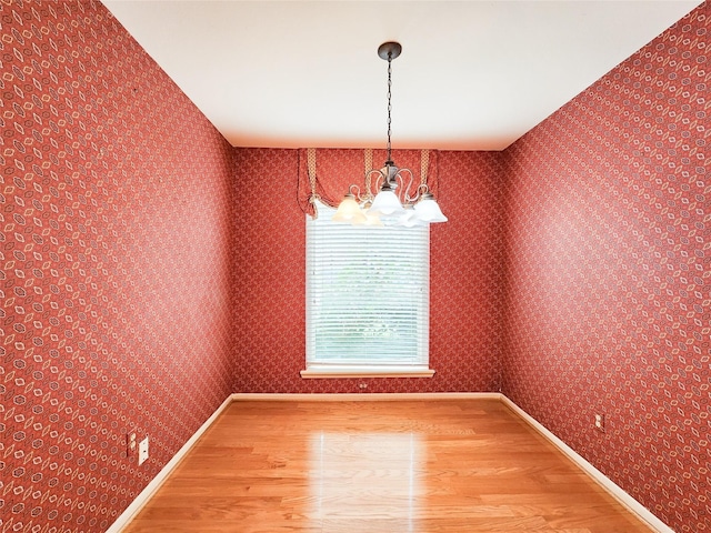 7910 Woodway Dr, Houston, TX 77063 - unfurnished dining area featuring wood finished floors, a chandelier, and baseboards