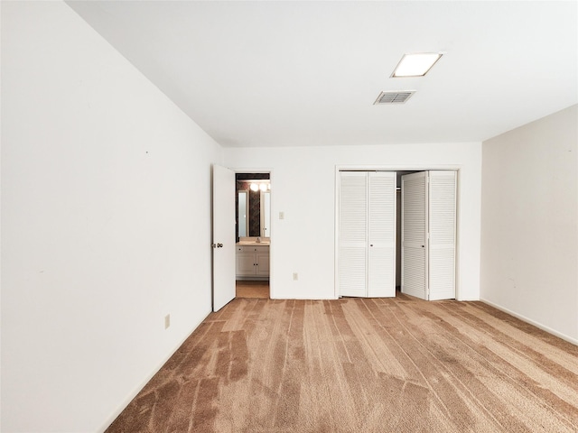 7910 Woodway Dr, Houston, TX 77063 - unfurnished bedroom featuring a closet, light carpet, and ensuite bathroom