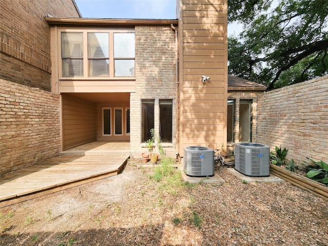 7910 Woodway Dr, Houston, TX 77063 - rear view of property featuring central AC unit, a chimney, and brick siding