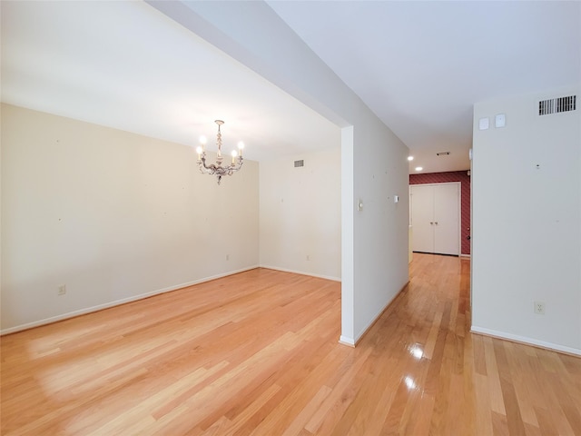 7910 Woodway Dr, Houston, TX 77063 - spare room featuring a chandelier, light wood-style floors, and baseboards