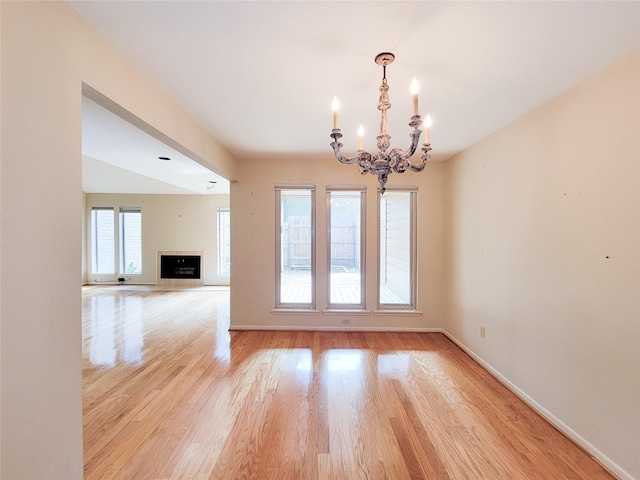 7910 Woodway Dr, Houston, TX 77063 - unfurnished room featuring a chandelier, light wood-type flooring, baseboards, and a fireplace