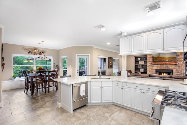 3315 E Bayou Dr, Shoreacres, TX 77571 - kitchen with ornamental molding, a fireplace, pendant lighting, white cabinets, and range