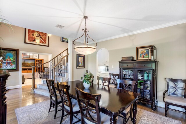 3315 E Bayou Dr, Shoreacres, TX 77571 - dining room featuring wood finished floors, stairs, and ornamental molding