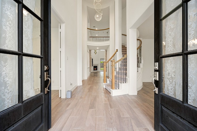 28946 Parker Ridge Dr, Katy, TX 77494 - entryway with baseboards, a chandelier, stairway, light wood-type flooring, and a high ceiling
