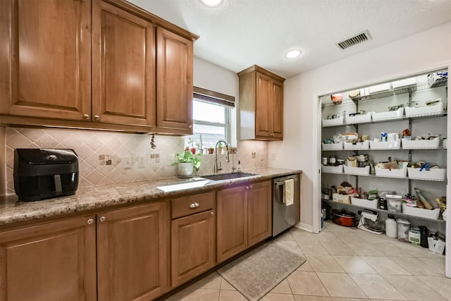 12938 Dermott Dr, Houston, TX 77065 - kitchen featuring a sink, dishwasher, backsplash, brown cabinets, and light tile patterned flooring