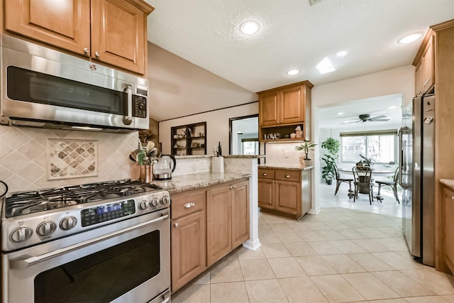 12938 Dermott Dr, Houston, TX 77065 - kitchen with stainless steel appliances, decorative backsplash, light stone counters, a ceiling fan, and recessed lighting