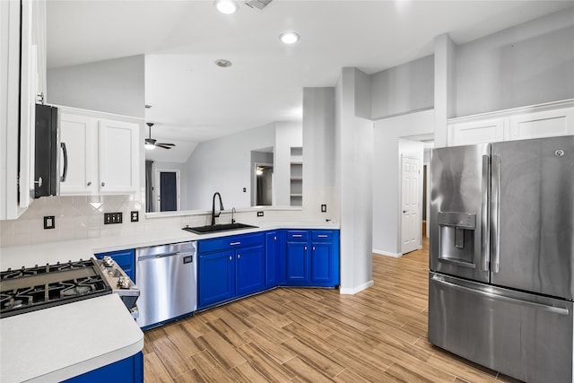 14925 Cypress Ridge Grove Ln, Cypress, TX 77429 - kitchen with appliances with stainless steel finishes, a sink, blue cabinetry, tasteful backsplash, and lofted ceiling