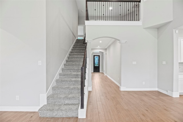 2411 Jitterbug Ln, Katy, TX 77493 - stairs with arched walkways, wood finished floors, a high ceiling, and baseboards