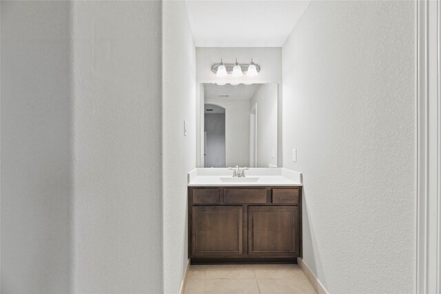 2411 Jitterbug Ln, Katy, TX 77493 - bathroom featuring tile patterned flooring, vanity, baseboards, and a textured wall