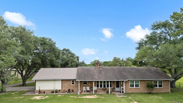 6825 Highland Rd, Santa Fe, TX 77517 - back of property featuring a lawn, brick siding, a chimney, and roof with shingles