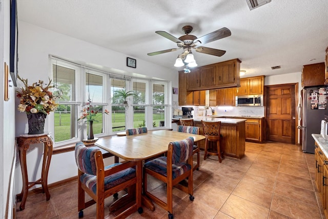 6825 Highland Rd, Santa Fe, TX 77517 - dining area featuring healthy amount of natural light, light tile patterned flooring, a textured ceiling, and ceiling fan