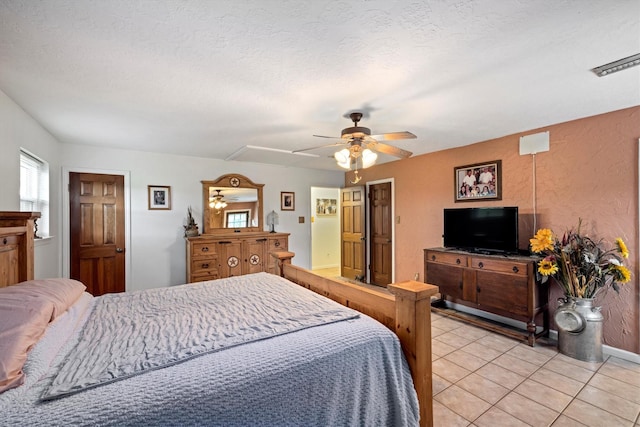 6825 Highland Rd, Santa Fe, TX 77517 - bedroom with light tile patterned flooring, a ceiling fan, a textured ceiling, and baseboards