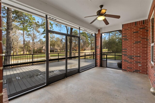 unfurnished sunroom featuring a ceiling fan