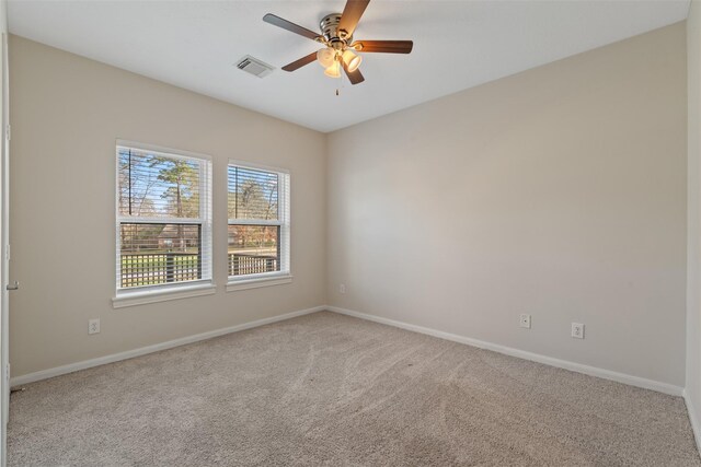 carpeted empty room with baseboards and a ceiling fan